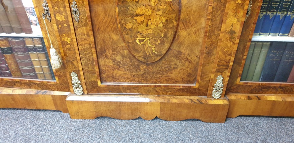 A low burr walnut and floral marquetry credenza bookcase featuring glazed side doors, a central solid panel door, and ornamental gilt-bronze mounts. View X