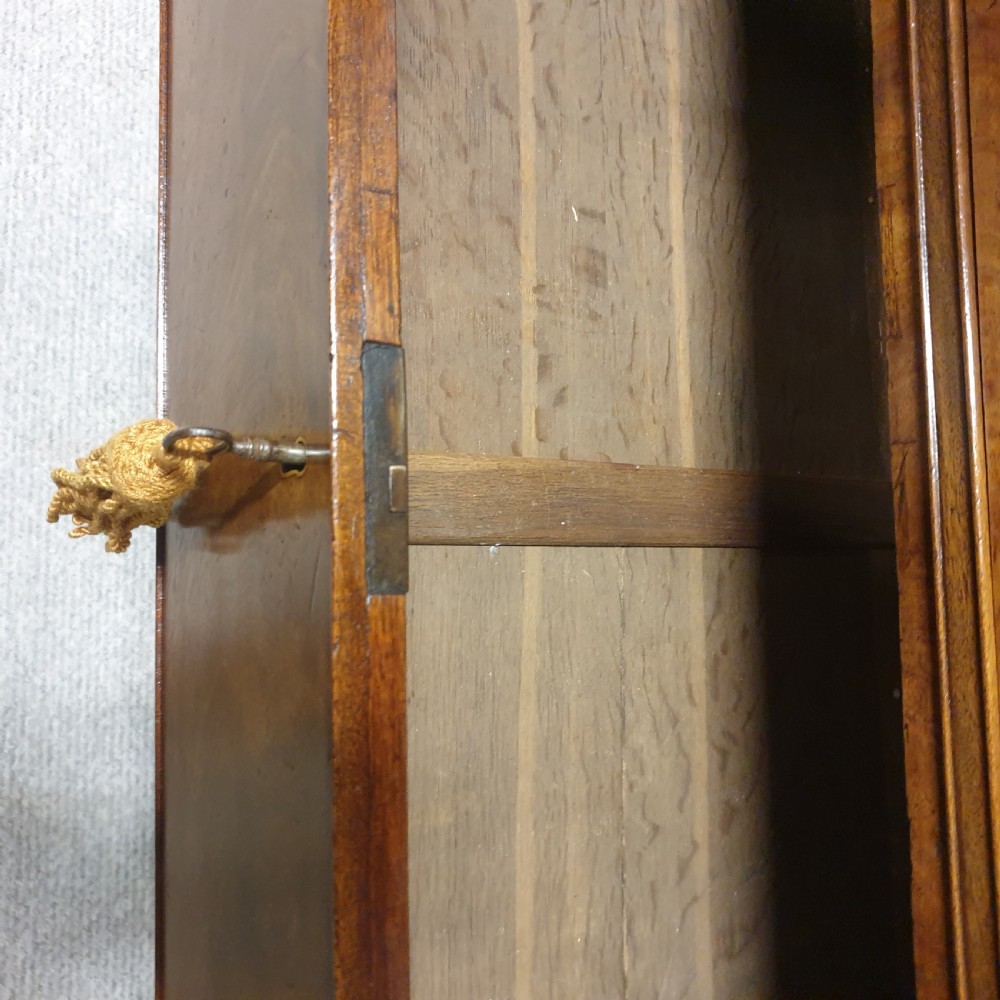 A Georgian mahogany open bookcase with a scalloped top frieze situated above a chest of three graduated drawers with brass handles. View X