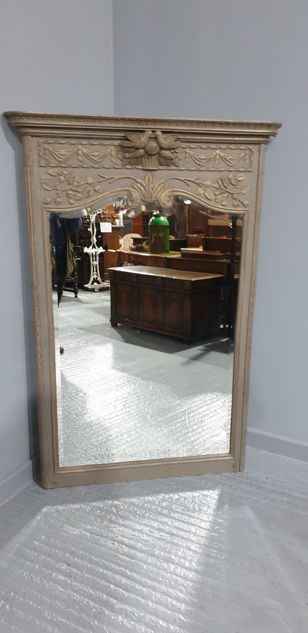 A French grey painted overmantel mirror featuring a carved dove frieze, floral swags, and an arched gilded frame. View IX