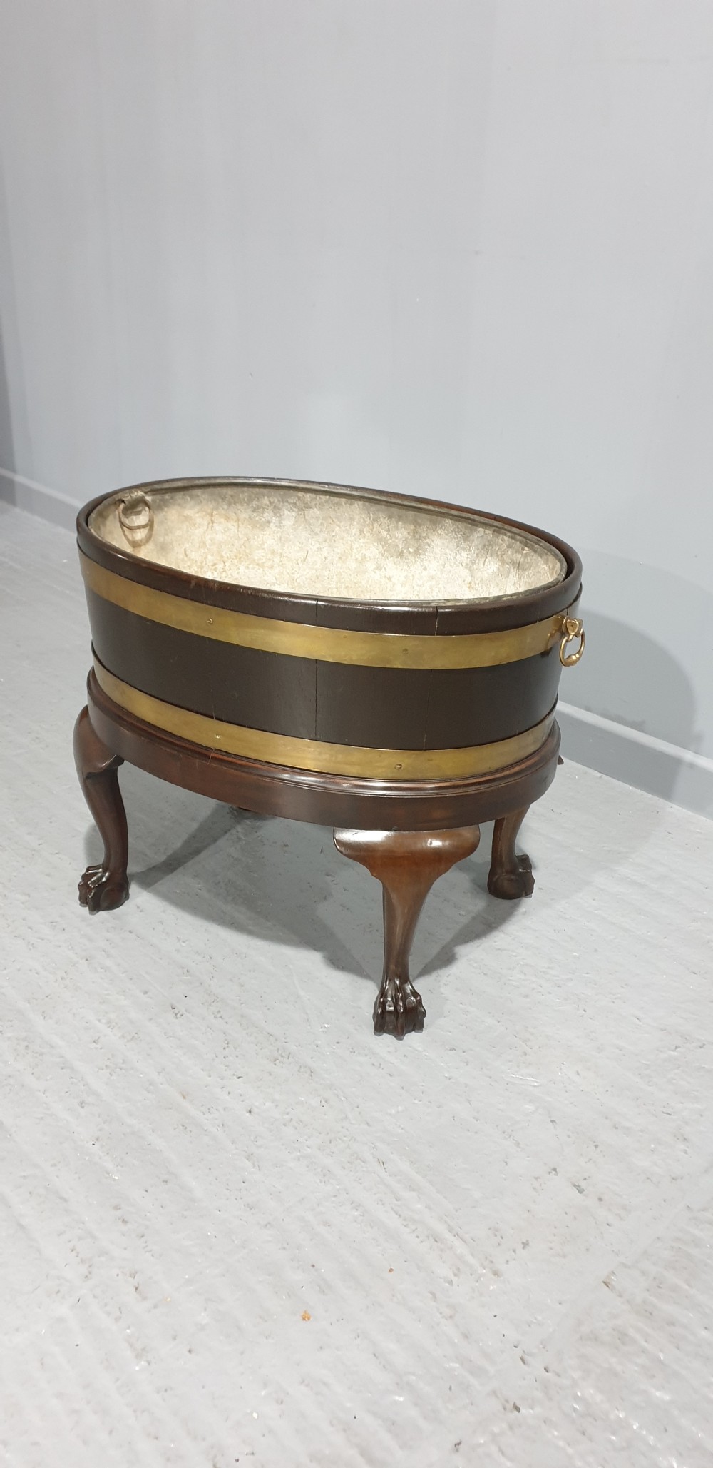 A circular Georgian mahogany wine cooler featuring twin brass bands, resting on carved cabriole legs with claw and ball feet. View III