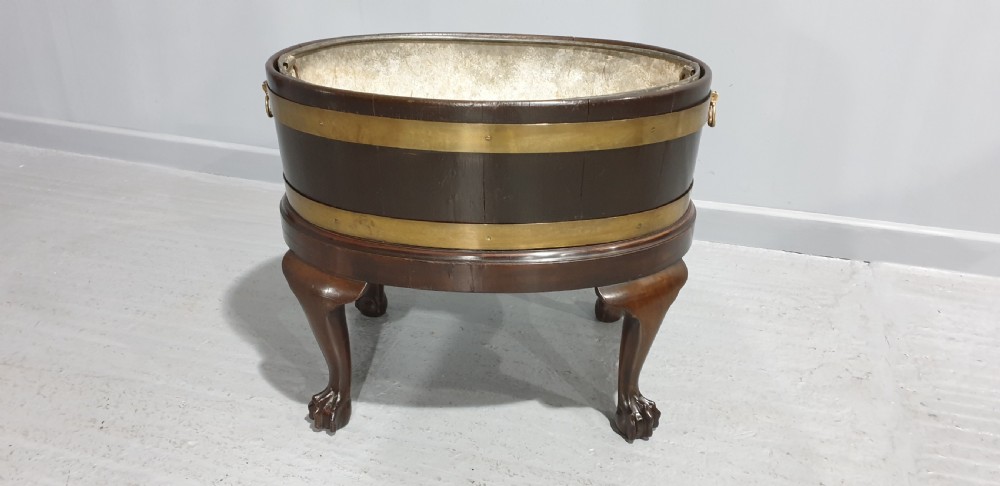 A circular Georgian mahogany wine cooler featuring twin brass bands, resting on carved cabriole legs with claw and ball feet. View IV