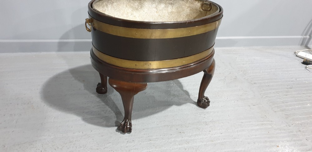 A circular Georgian mahogany wine cooler featuring twin brass bands, resting on carved cabriole legs with claw and ball feet. View VI
