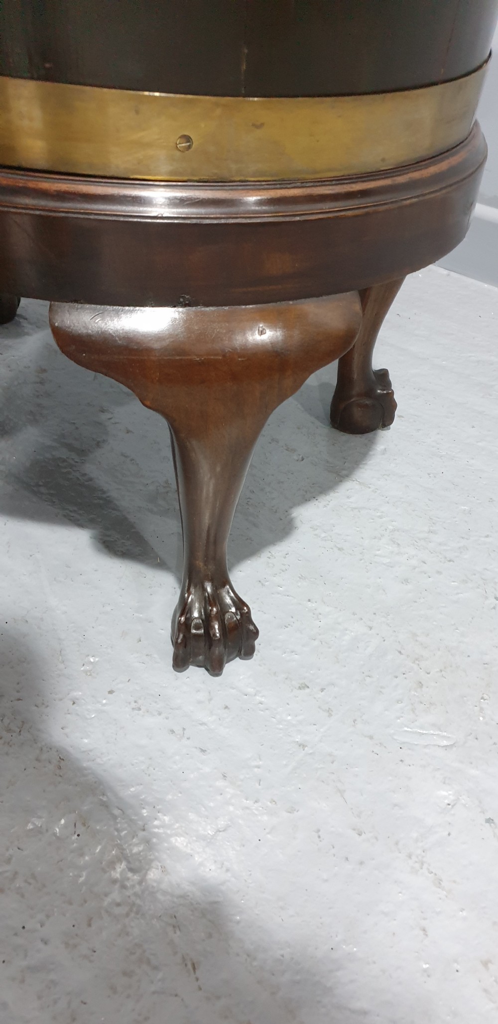 A circular Georgian mahogany wine cooler featuring twin brass bands, resting on carved cabriole legs with claw and ball feet. View VII