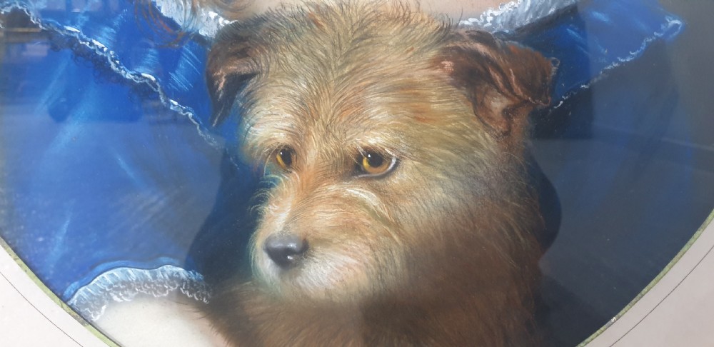 An antique oval Victorian portrait depicting a young girl in a blue dress holding a small dog, set within a carved gold gilded frame. View VIII