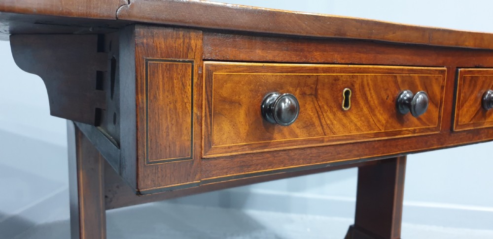 An 18th-century mahogany drop-leaf sofa table with two frieze drawers, crossbanded inlay, sabre legs, and brass castors. View XIII