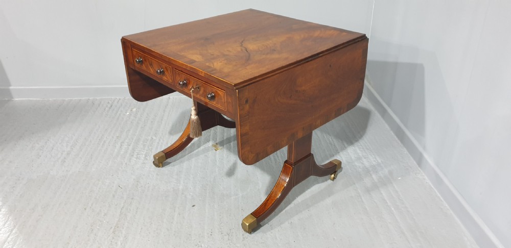 An 18th-century mahogany drop-leaf sofa table with two frieze drawers, crossbanded inlay, sabre legs, and brass castors. View XV