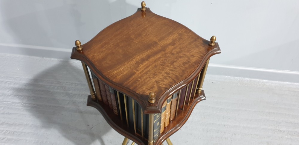 A small square revolving mahogany bookstand featuring brass vertical spindles, corner finials, and a tall tripod brass base with claw feet. View VI