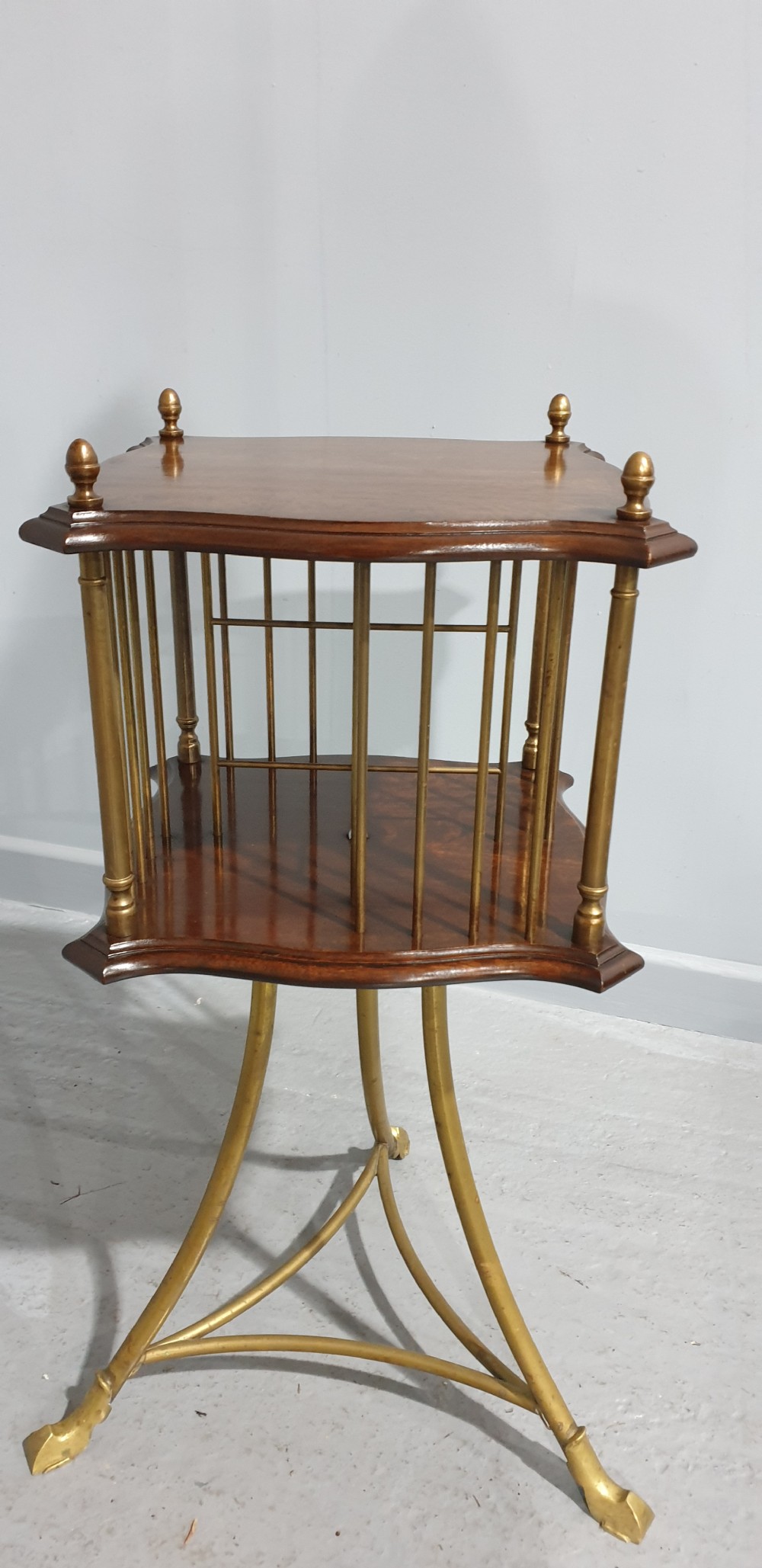 A small square revolving mahogany bookstand featuring brass vertical spindles, corner finials, and a tall tripod brass base with claw feet. View IX