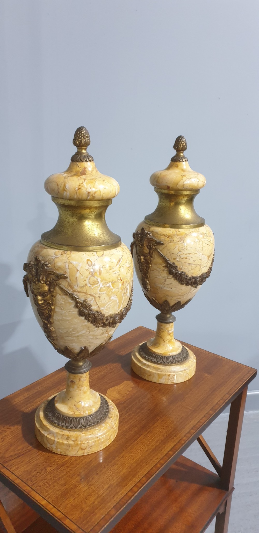 A pair of yellow veined marble cassolette urns with gilt bronze floral swags and pineapple finials. View IX