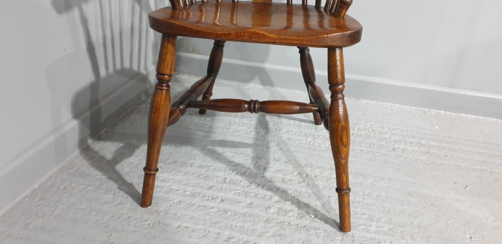 A traditional ash and elm Windsor armchair featuring a hoop back, central pierced splat, turned spindles, and a contoured wooden seat. View III