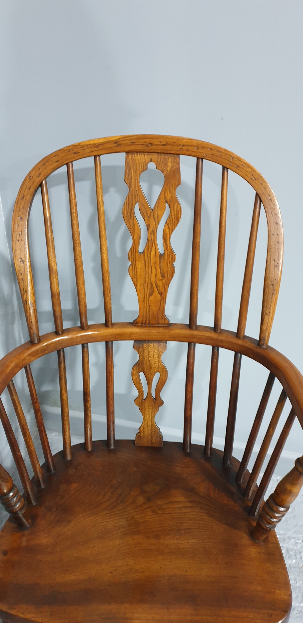 A traditional ash and elm Windsor armchair featuring a hoop back, central pierced splat, turned spindles, and a contoured wooden seat. View V
