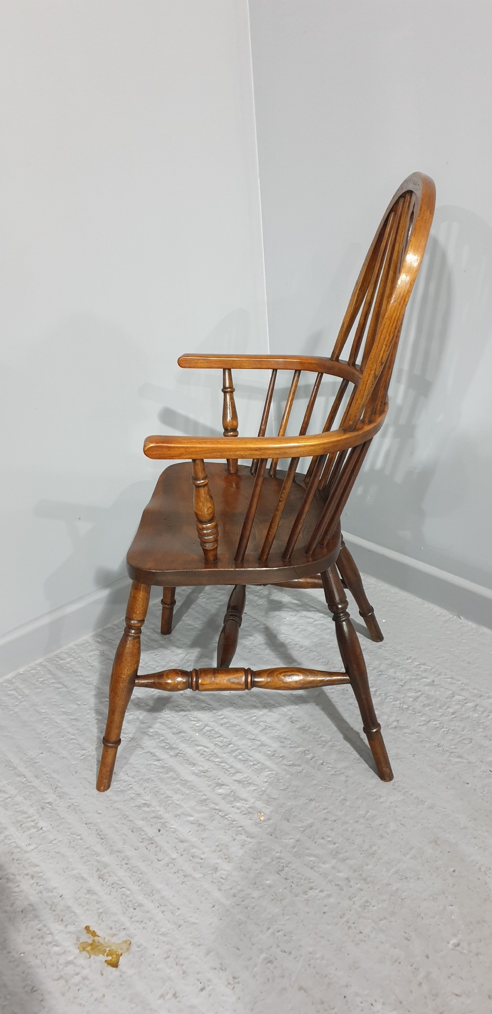 A traditional ash and elm Windsor armchair featuring a hoop back, central pierced splat, turned spindles, and a contoured wooden seat. View VI