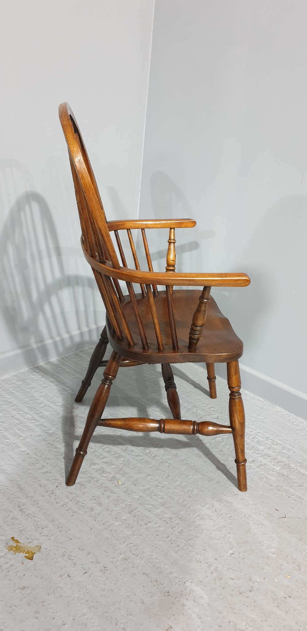 A traditional ash and elm Windsor armchair featuring a hoop back, central pierced splat, turned spindles, and a contoured wooden seat. View VIII