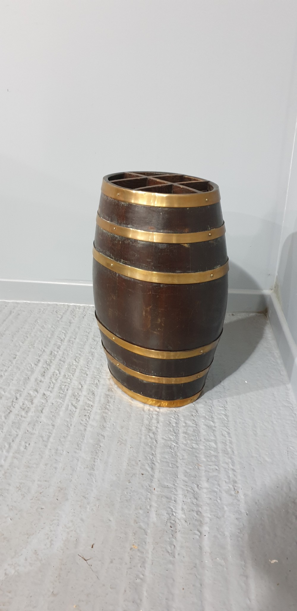 A dark oak barrel stick stand bound with brass hoops and featuring internal grid dividers at the top. View III