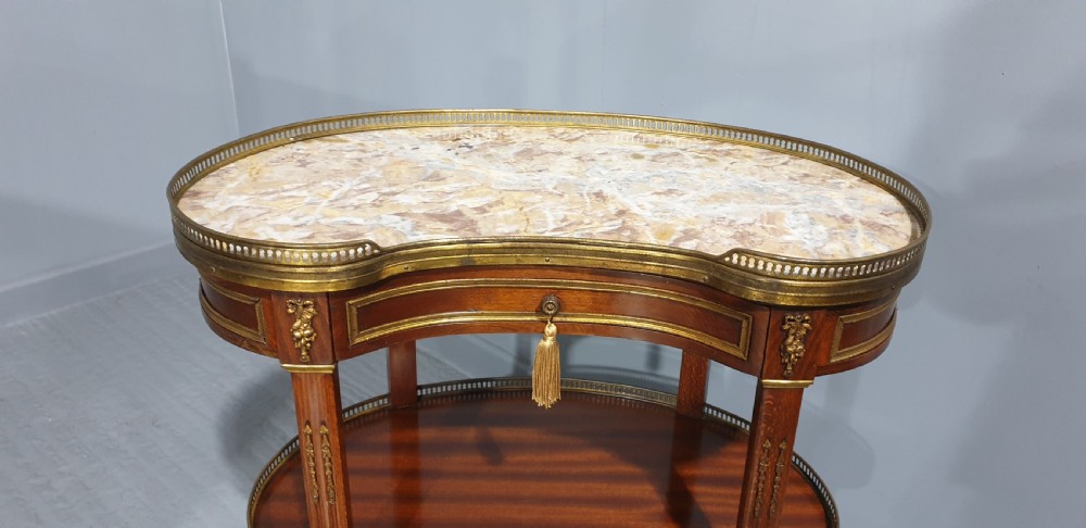A French kidney-shaped mahogany side table featuring a marble top, upper brass gallery, lower shelf, and gilt bronze mounts. View V