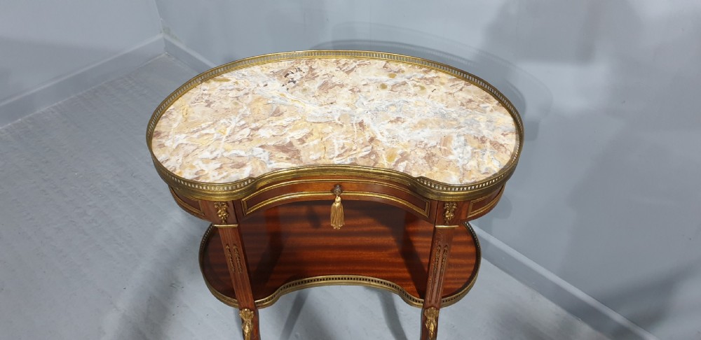 A French kidney-shaped mahogany side table featuring a marble top, upper brass gallery, lower shelf, and gilt bronze mounts. View VI