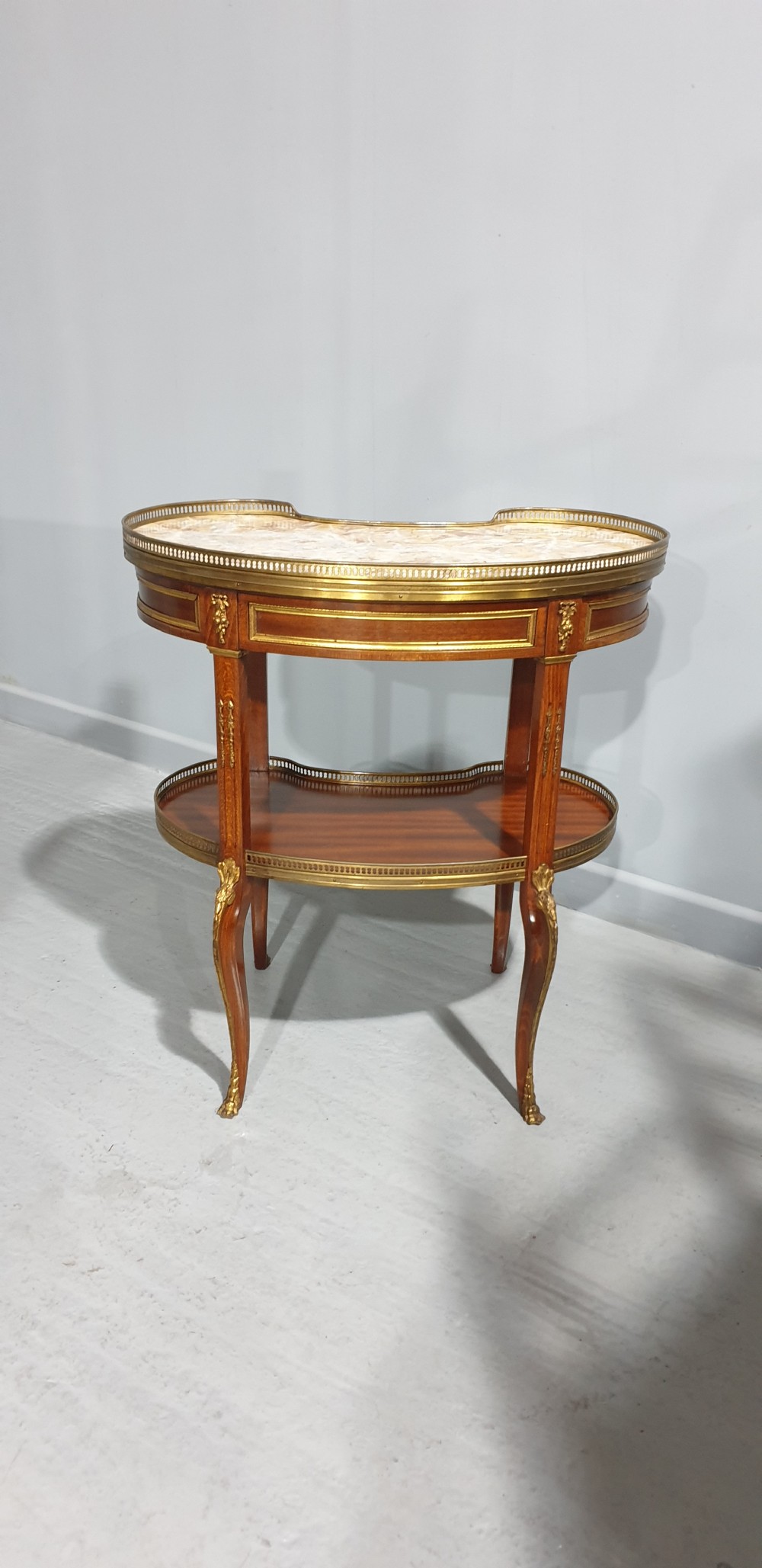 A French kidney-shaped mahogany side table featuring a marble top, upper brass gallery, lower shelf, and gilt bronze mounts. View VIII