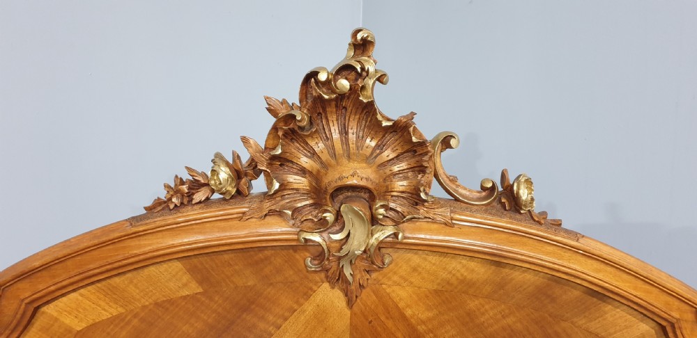 A French Louis XV style walnut bed frame featuring quarter-matched veneered panels and parcel gilt hand-carved cresting on the headboard and footboard. View VII