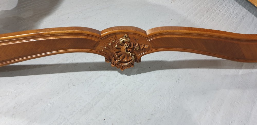 A French Louis XV style walnut bed frame featuring quarter-matched veneered panels and parcel gilt hand-carved cresting on the headboard and footboard. View IX