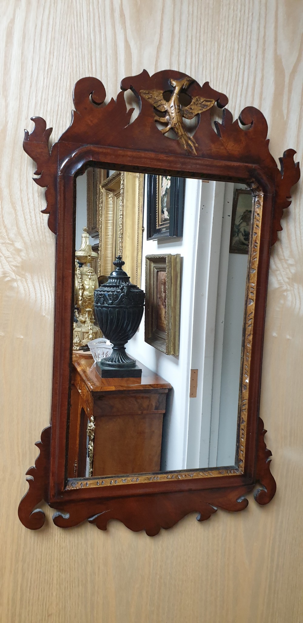 A Georgian mahogany fretwork wall mirror featuring a scrolled frame, a gilded bird motif at the top crest, and a gilded inner border. View II