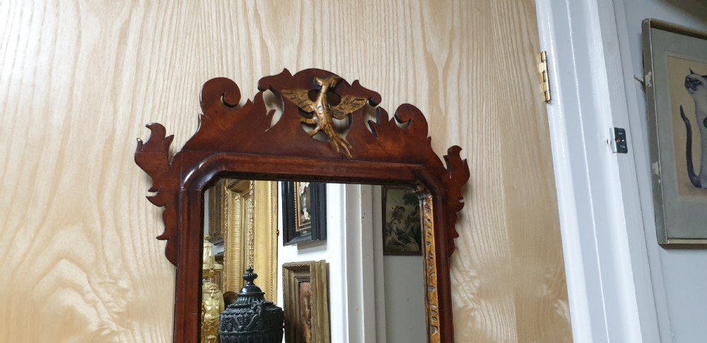 A Georgian mahogany fretwork wall mirror featuring a scrolled frame, a gilded bird motif at the top crest, and a gilded inner border. View IV