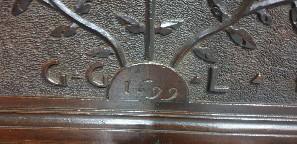 A dark brown carved wood Italian cassone coffer featuring two foliate relief panels and carved lion paw feet. View IV