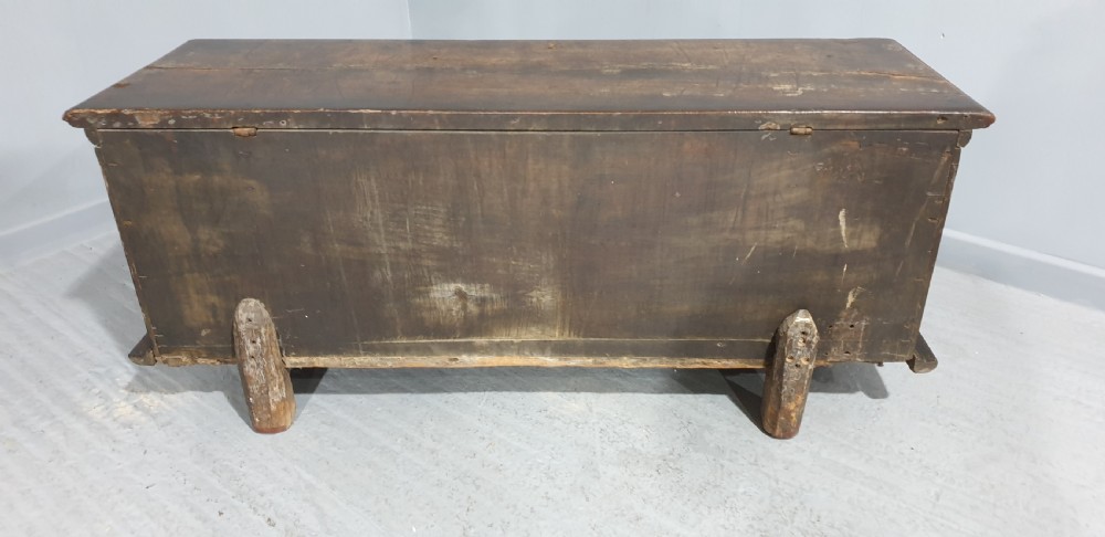 A dark brown carved wood Italian cassone coffer featuring two foliate relief panels and carved lion paw feet. View XII