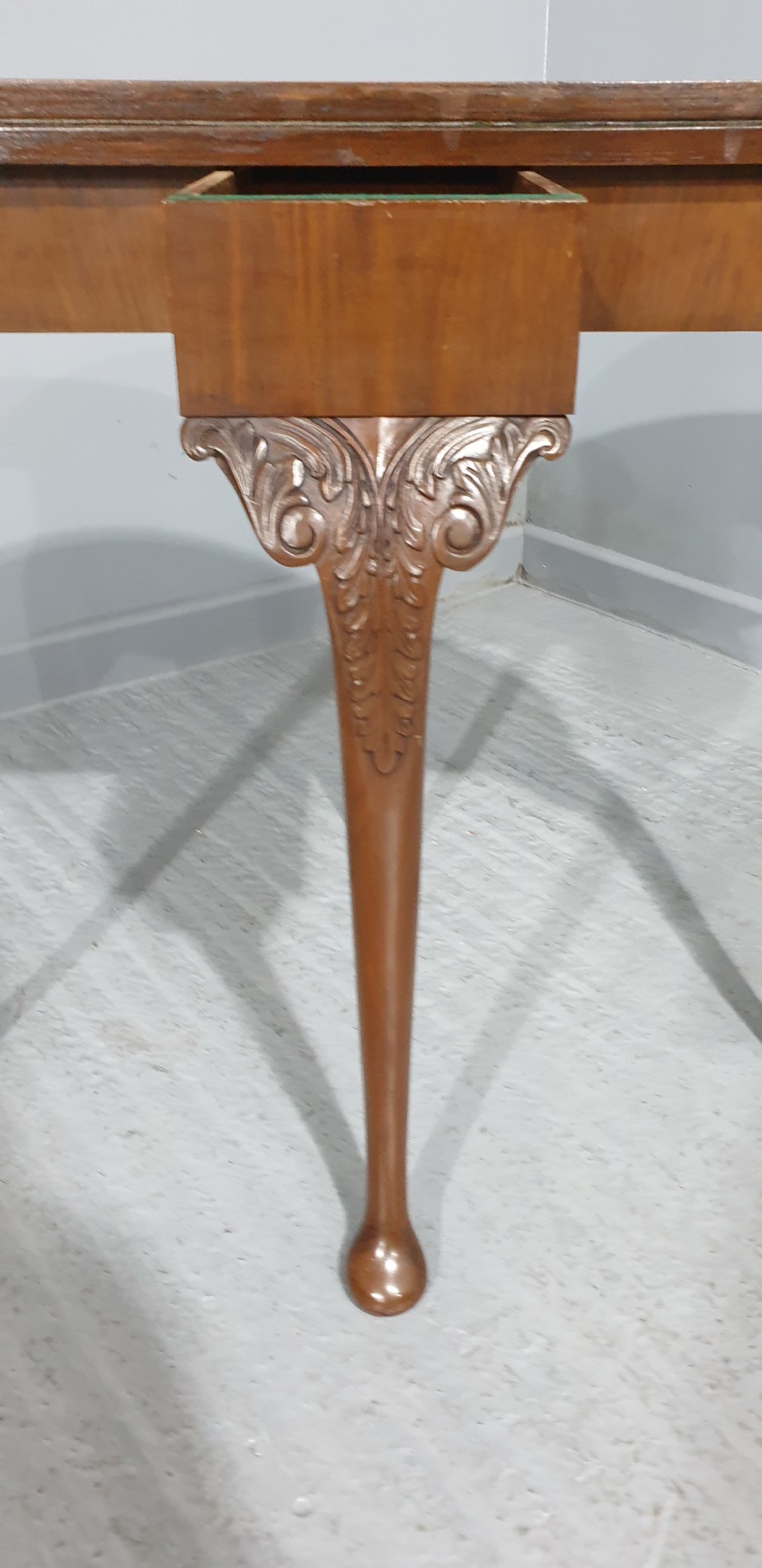 A semi-circular burr walnut games table with a fold-over top, carved edge moulding, and cabriole legs featuring carved knees and pad feet. View VIII