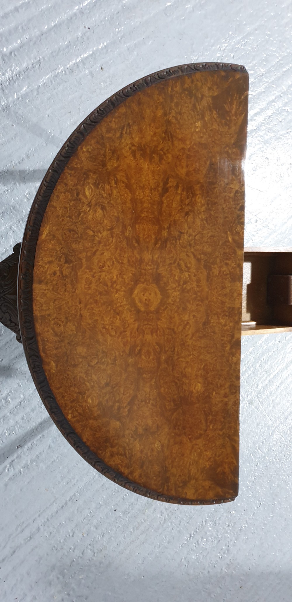 A semi-circular burr walnut games table with a fold-over top, carved edge moulding, and cabriole legs featuring carved knees and pad feet. View IX