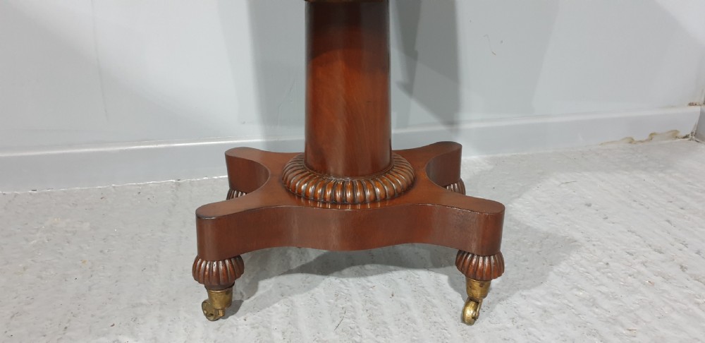 A William IV mahogany pedestal wine cellarette with marquetry inlay, gadrooned trim, and a quadform base on brass castors. View III