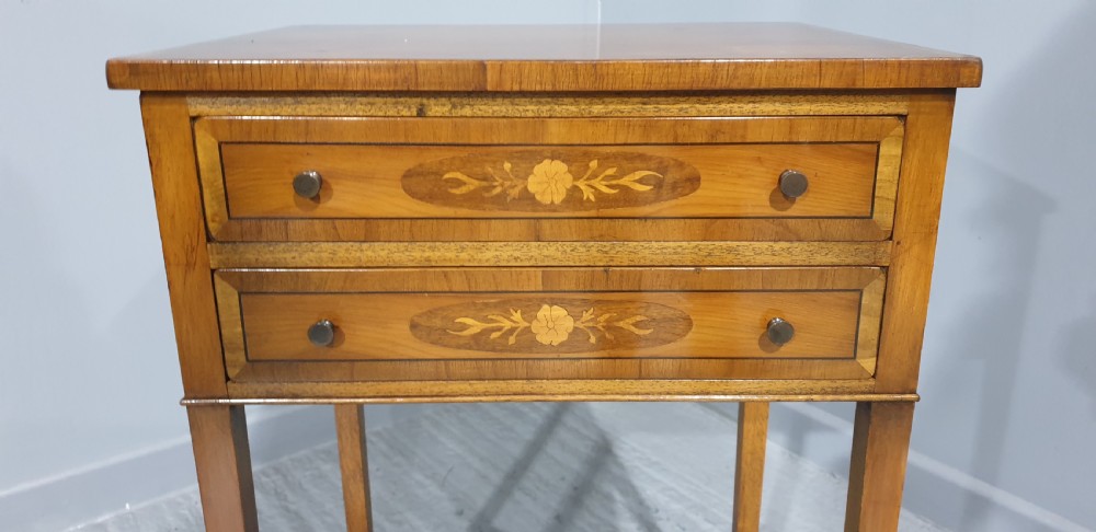 A tall yew wood side table featuring two drawers adorned with oval floral marquetry inlays, slim square legs, and an X-frame stretcher base. View III