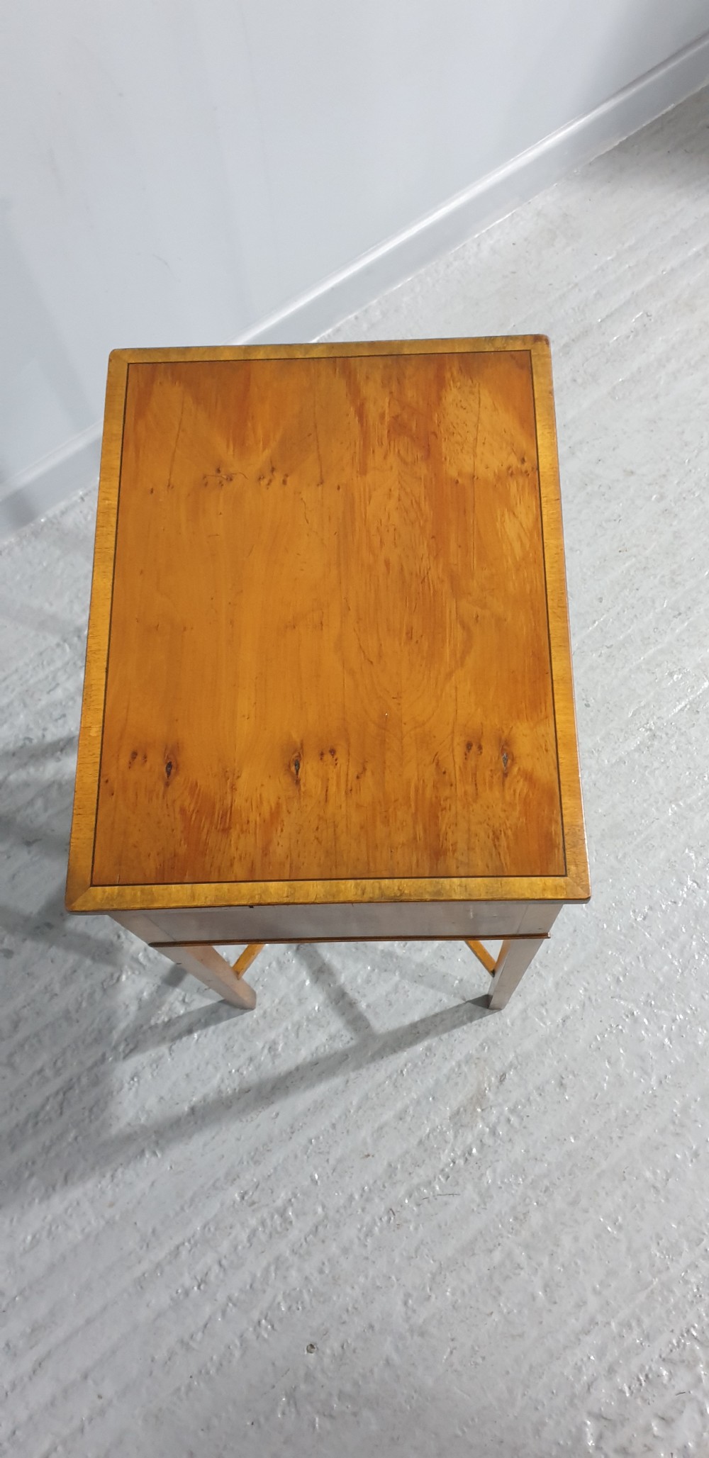 A tall yew wood side table featuring two drawers adorned with oval floral marquetry inlays, slim square legs, and an X-frame stretcher base. View VI