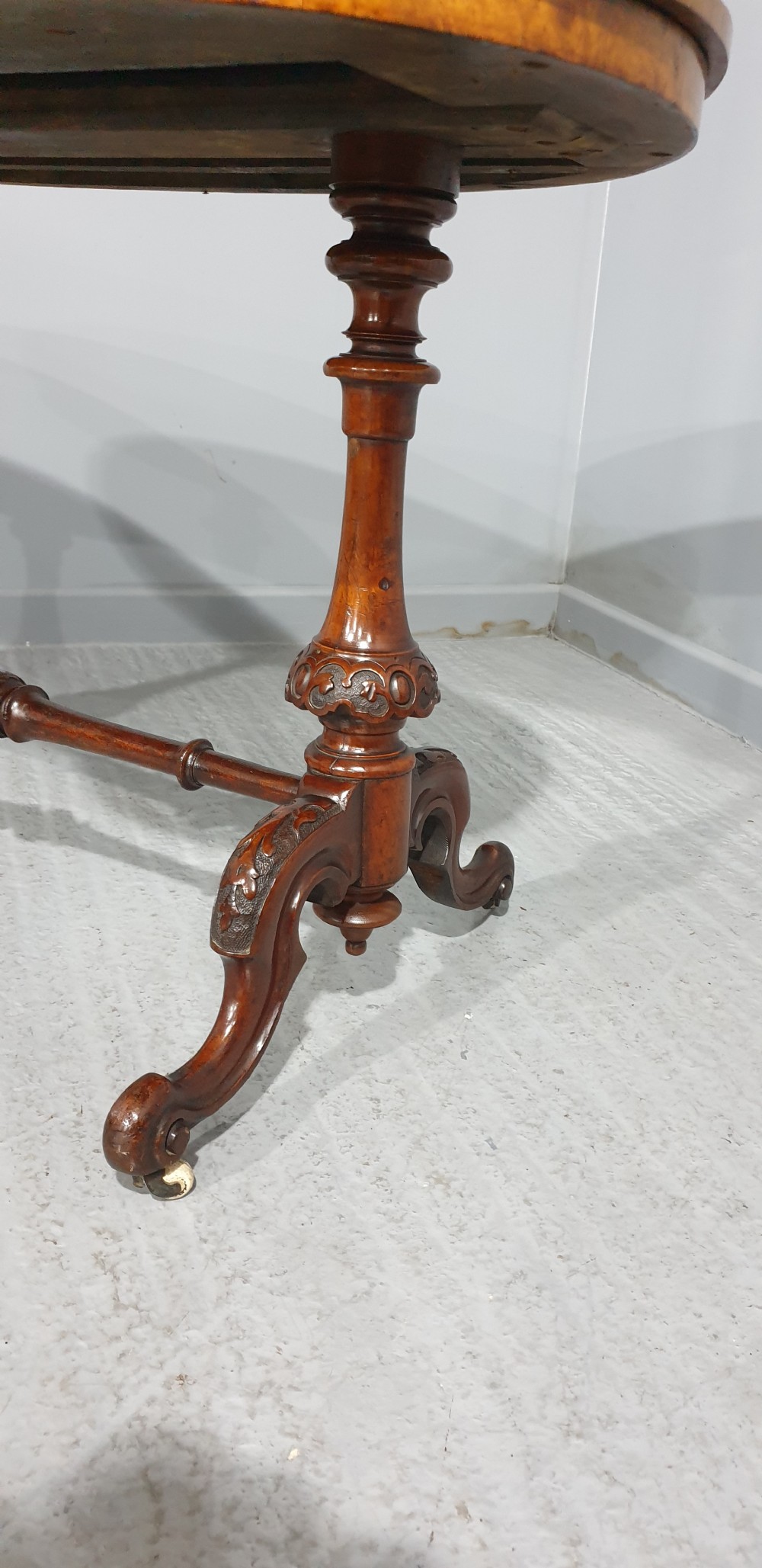 A Victorian kidney-shaped writing desk crafted from burr walnut with a green leather inset top and carved turned legs joined by a stretcher. View V