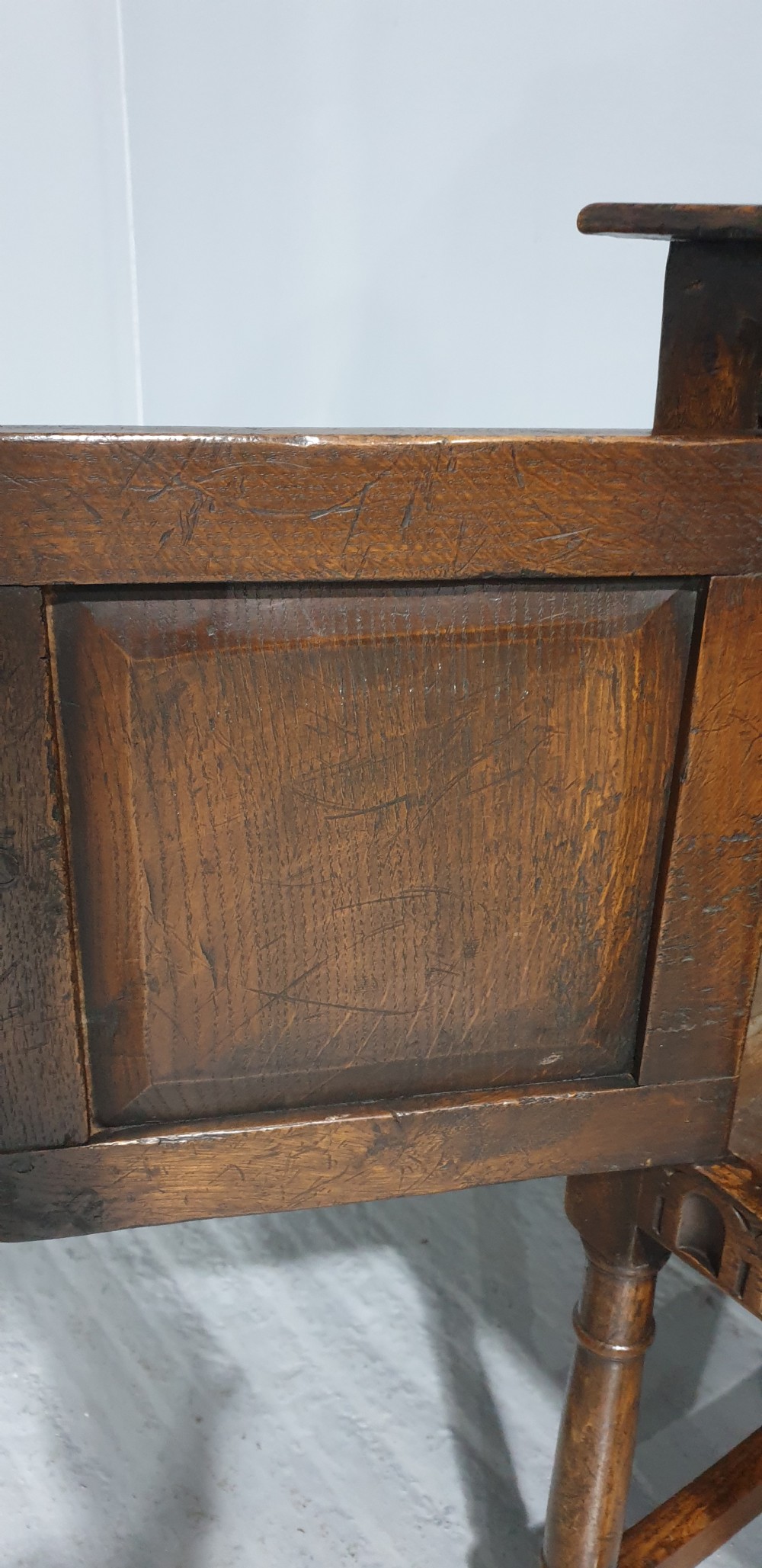 A small dark oak carved sideboard with two decorative panelled doors, turned legs, and lower stretchers. View IX