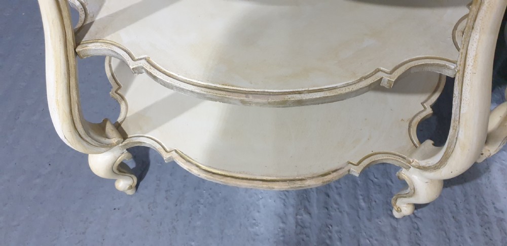 A pair of cream painted three-tier occasional lamp tables with cabriole legs and painted floral medallion tops. View V