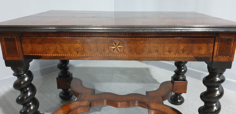 An antique laburnum and walnut oyster veneered centre table featuring barley twist legs, a star inlay on the drawer front, a shaped stretcher, and ball feet. View II