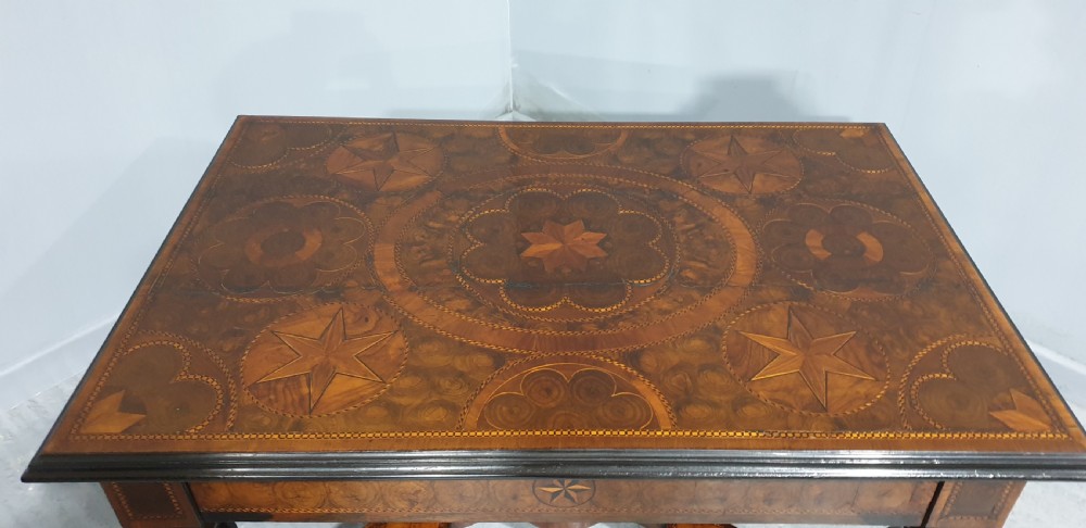 An antique laburnum and walnut oyster veneered centre table featuring barley twist legs, a star inlay on the drawer front, a shaped stretcher, and ball feet. View V