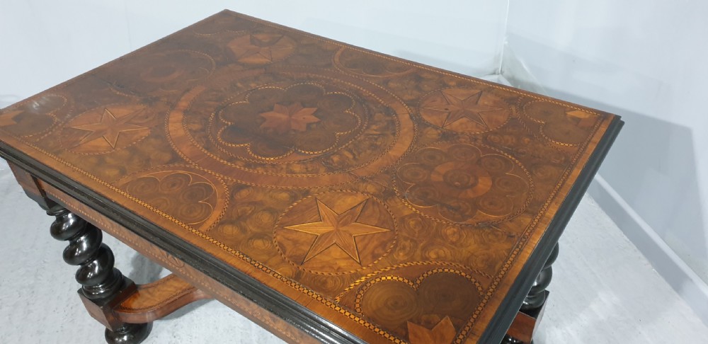 An antique laburnum and walnut oyster veneered centre table featuring barley twist legs, a star inlay on the drawer front, a shaped stretcher, and ball feet. View VII