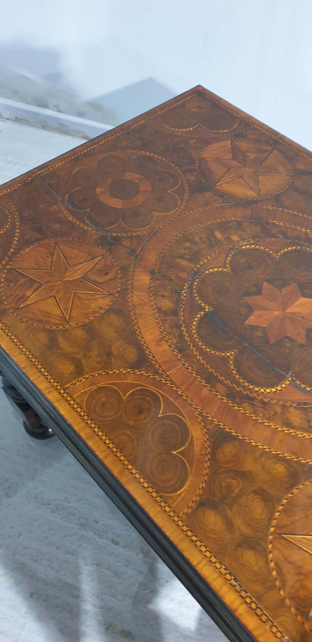 An antique laburnum and walnut oyster veneered centre table featuring barley twist legs, a star inlay on the drawer front, a shaped stretcher, and ball feet. View XV