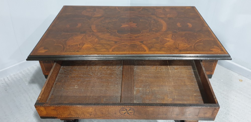 An antique laburnum and walnut oyster veneered centre table featuring barley twist legs, a star inlay on the drawer front, a shaped stretcher, and ball feet. View XVIII