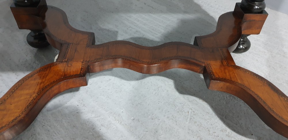 An antique laburnum and walnut oyster veneered centre table featuring barley twist legs, a star inlay on the drawer front, a shaped stretcher, and ball feet. View XX