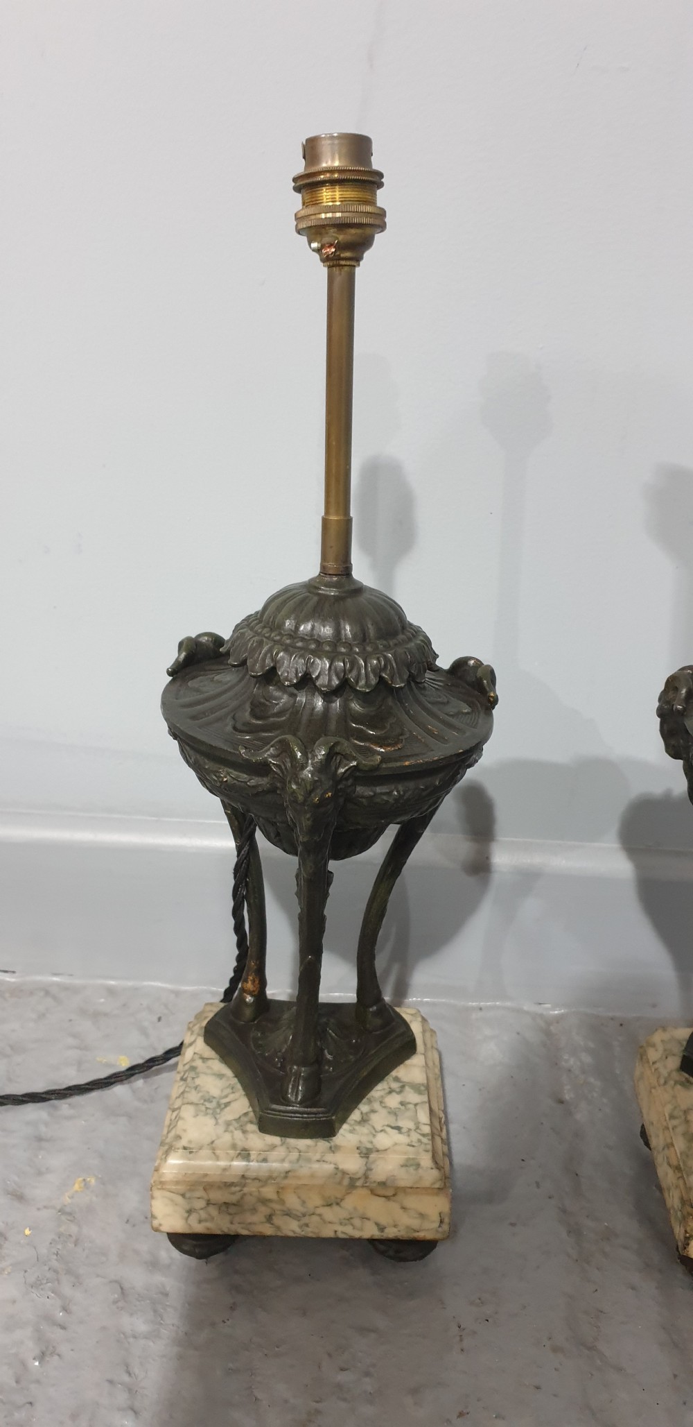 A pair of French spelter table lamps crafted in the form of classical urns set on square veined marble bases. View II