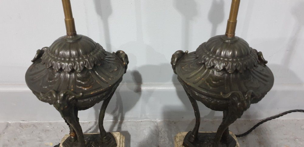 A pair of French spelter table lamps crafted in the form of classical urns set on square veined marble bases. View III