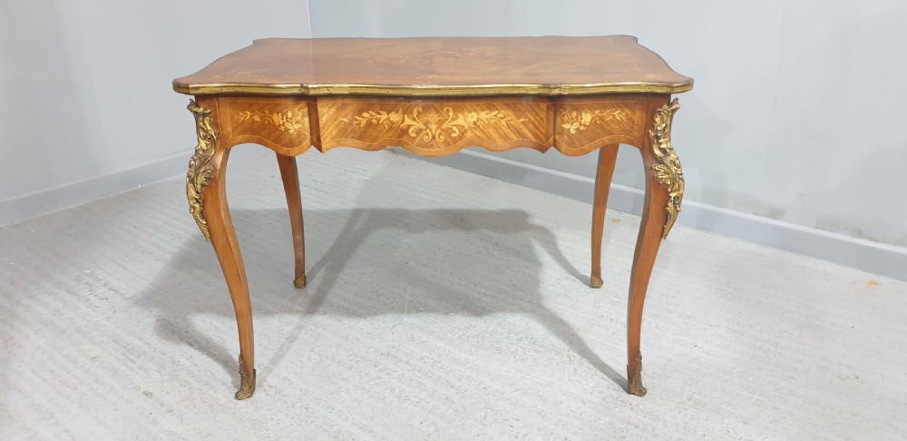 A French Louis XV style bureau plat decorated with floral marquetry inlay, curved cabriole legs, and ornate gilt bronze mounts. View IV