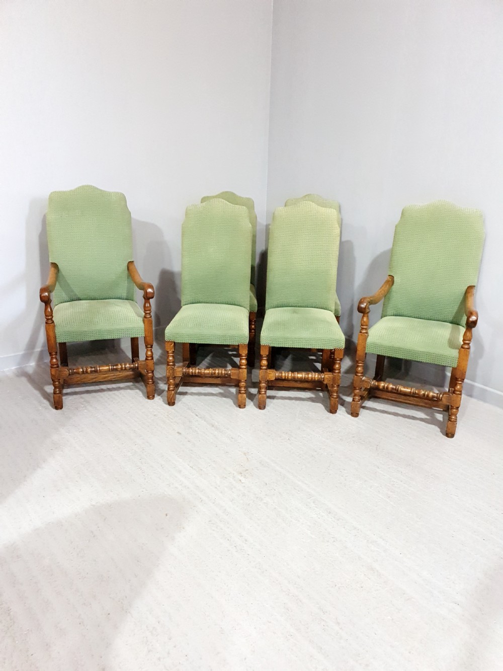 A set of six oak dining chairs with green textured upholstery, including two open-arm carvers and four side chairs with turned legs and stretchers. View III