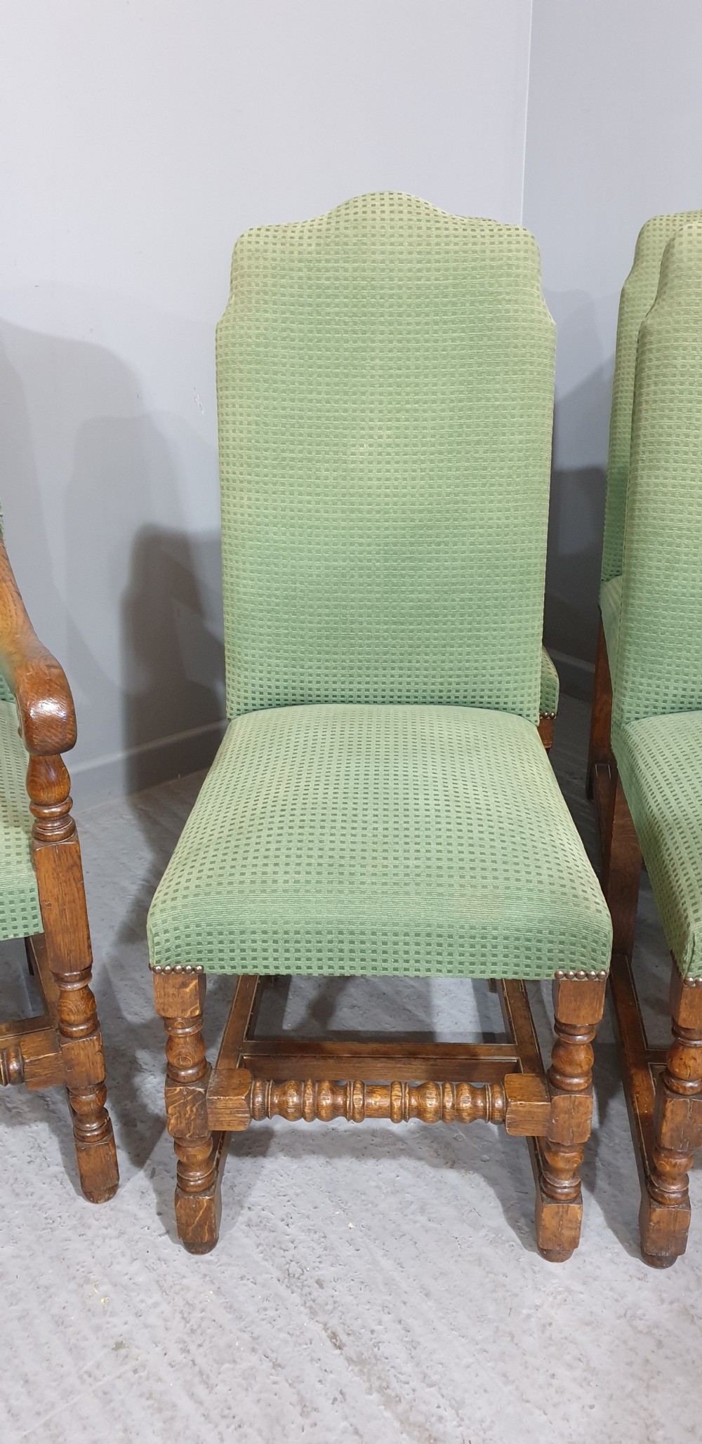 A set of six oak dining chairs with green textured upholstery, including two open-arm carvers and four side chairs with turned legs and stretchers. View IX