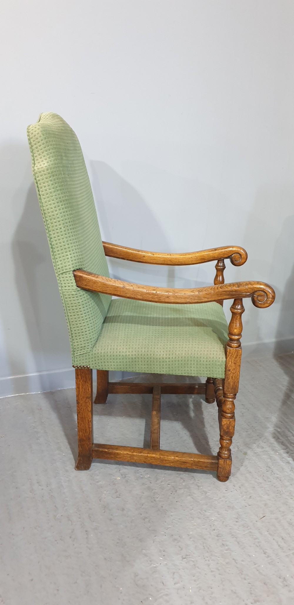 A set of six oak dining chairs with green textured upholstery, including two open-arm carvers and four side chairs with turned legs and stretchers. View X