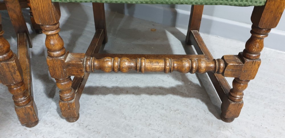 A set of six oak dining chairs with green textured upholstery, including two open-arm carvers and four side chairs with turned legs and stretchers. View XIII