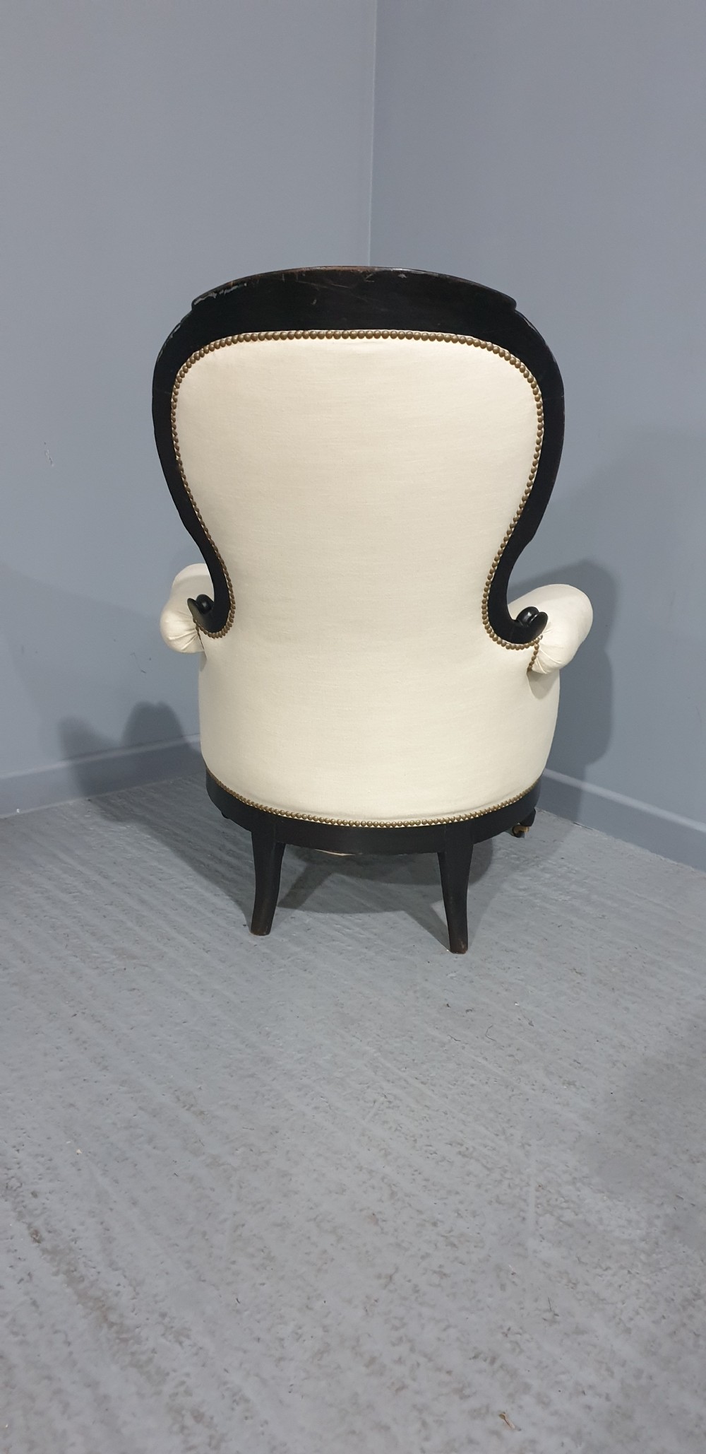 Victorian ebonised spoon-back armchair with off-white upholstery, brass castors, and cabriole legs. View IX