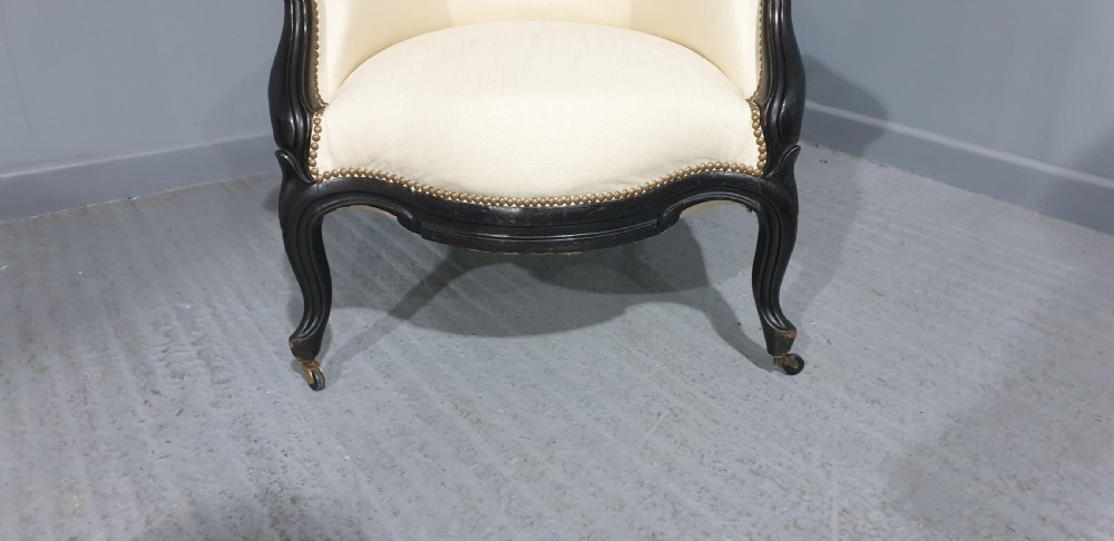 Victorian ebonised spoon-back armchair with off-white upholstery, brass castors, and cabriole legs. View XI